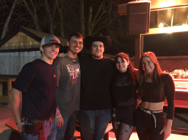 Logan Bennett (center left) and Noah Silvestro (center) stand around the Dusty Armadillos outdoor patio with friends on Dec. 15, 2023. 