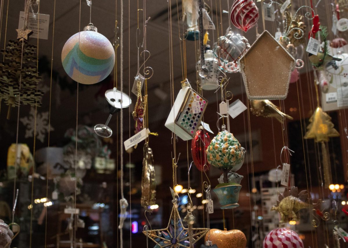 Christmas ornaments are hung up for display in the windows of McKay Bricker Framings store in Kent, Ohio on Dec. 10, 2023.