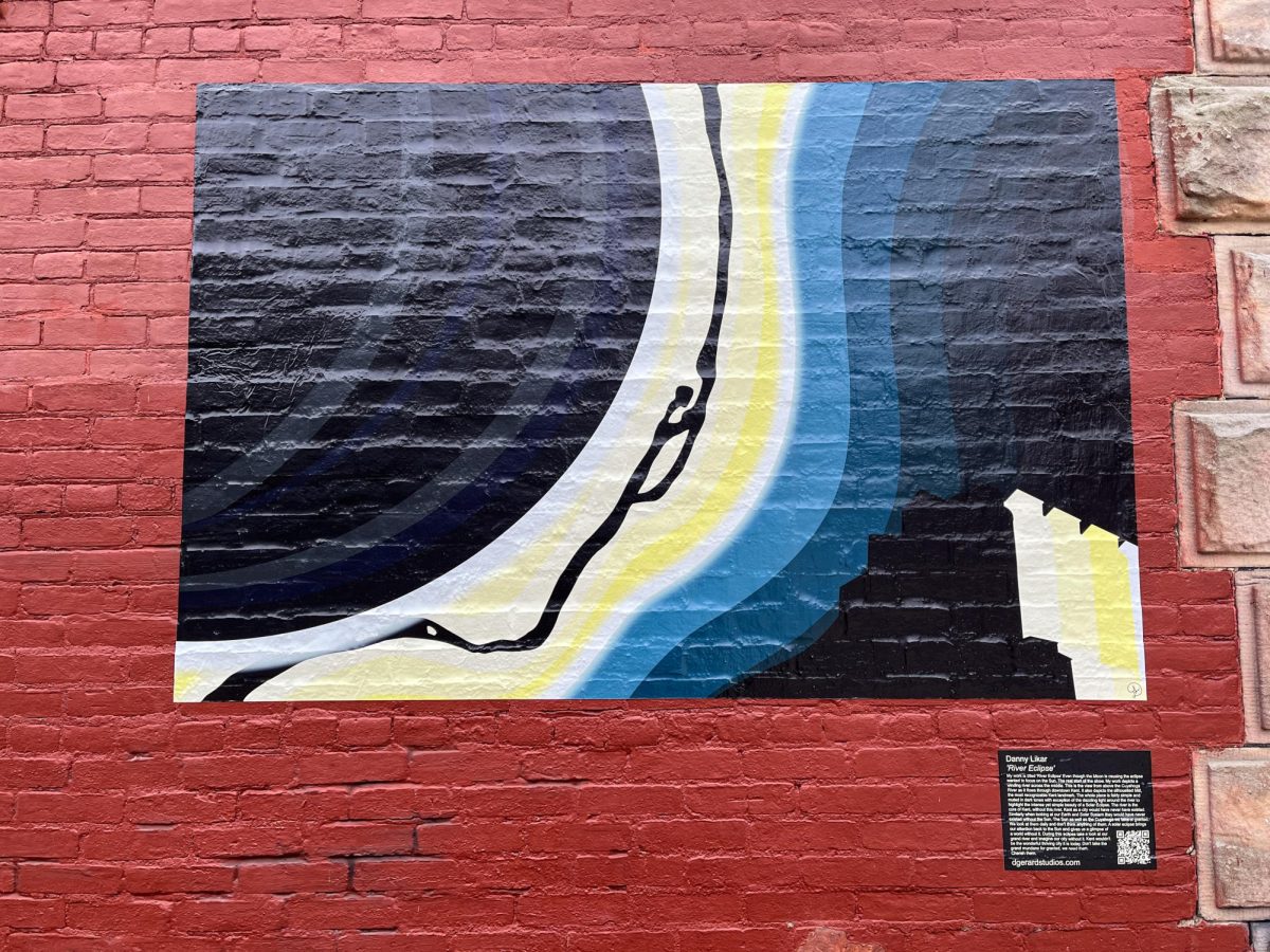 The River Eclipse, a work by Danny Likar is on display on the side of Grazers in Downtown Kent on March 20, 2024. The work is meant to depict a view of the Cuyahoga River from above during the eclipse. 