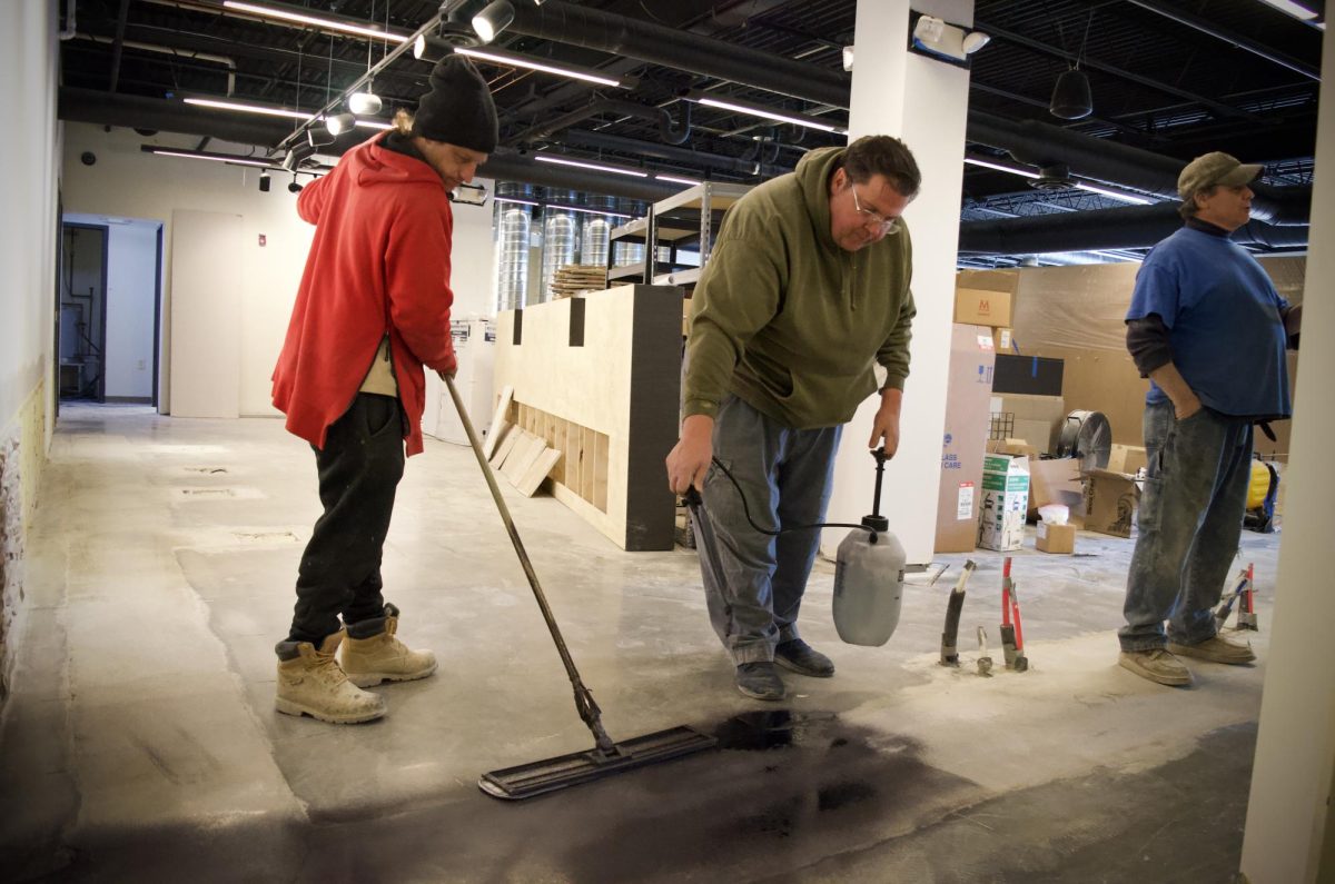 Spencer Stash and Jeremiah Krause, employees of the Contact Concrete Publishment, work on redoing the floor of Evelyn Dickerson Hair Design on March 22, 2024, as the space undergoes renovations prior to the official opening of the salon. The business will be located at 175 E. Erie Street.
