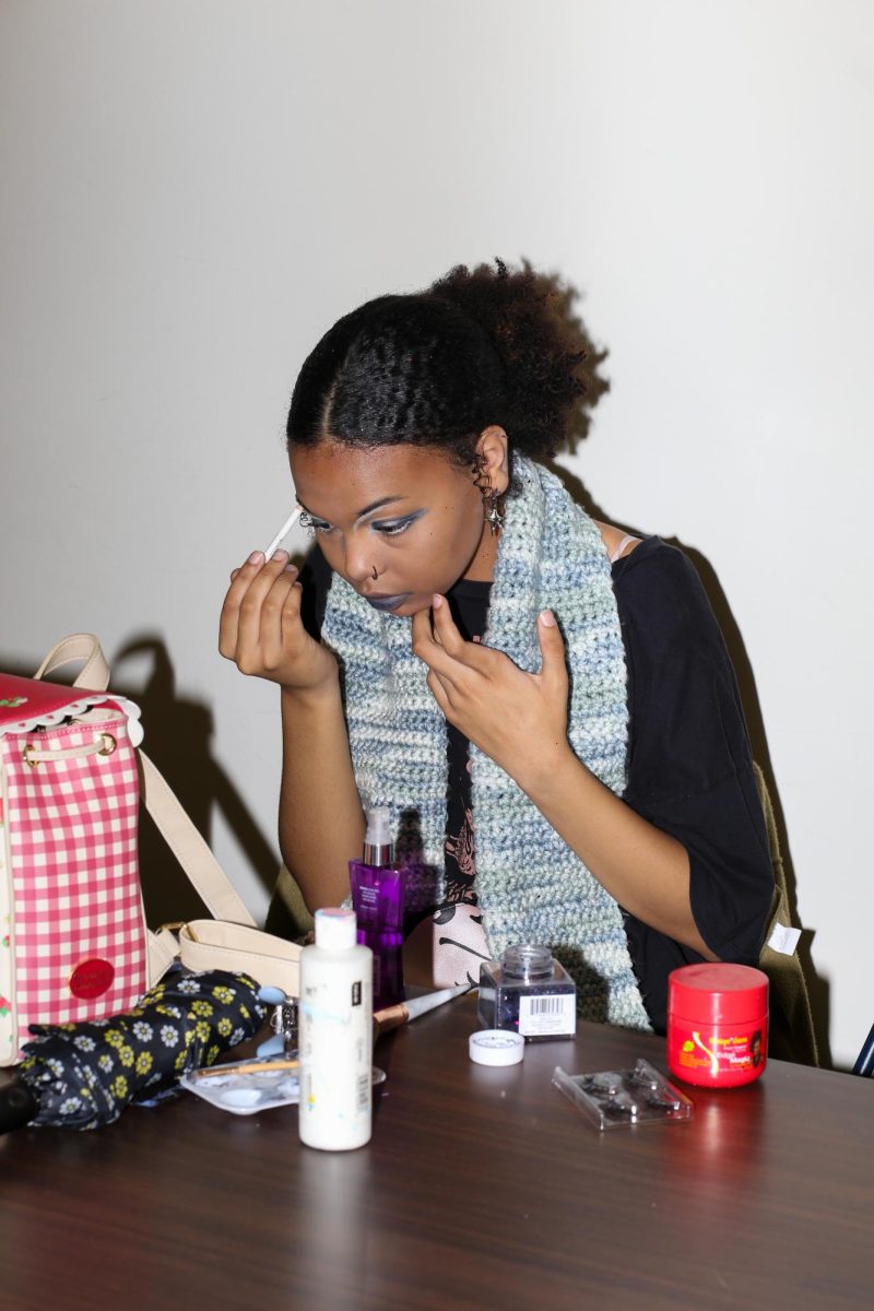 Olivia Tharp does her make up in preparation of the Fabric Pantry annual fashion show on March 9, 2024.