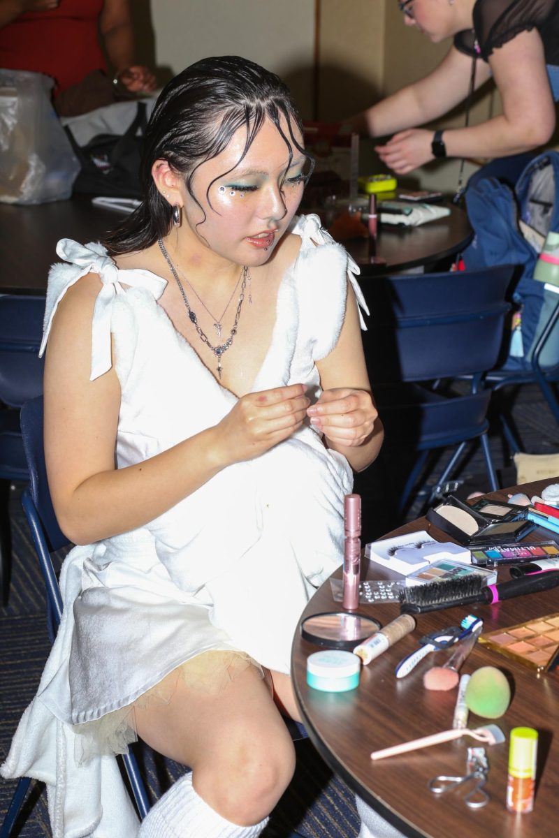 A model does her make up in preparation of the Fabric Pantry annual fashion show on March 9, 2024.