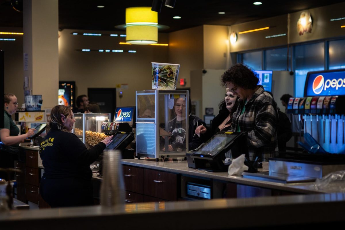 Alexandra Deist, Kent State art history major, helps some customers at the counter of Kent Plaza Theater on March 23, 2024.