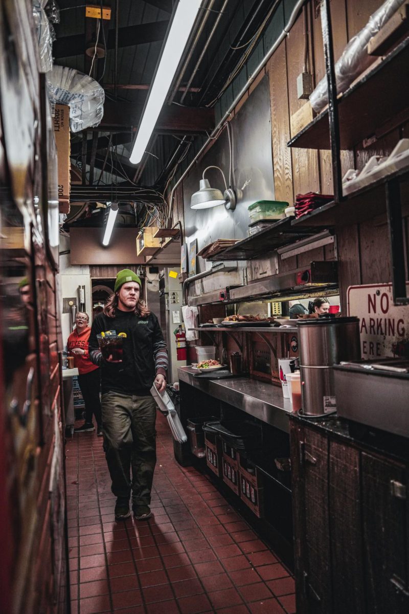 Employees at Mikes Place carry orders through the kitchen.
