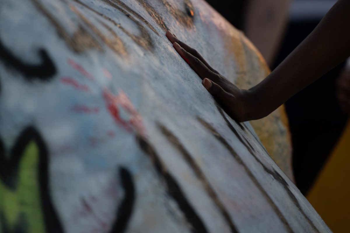 Participants of the protest on April 15, 2024, use paint to leave red handprints on the Rock.