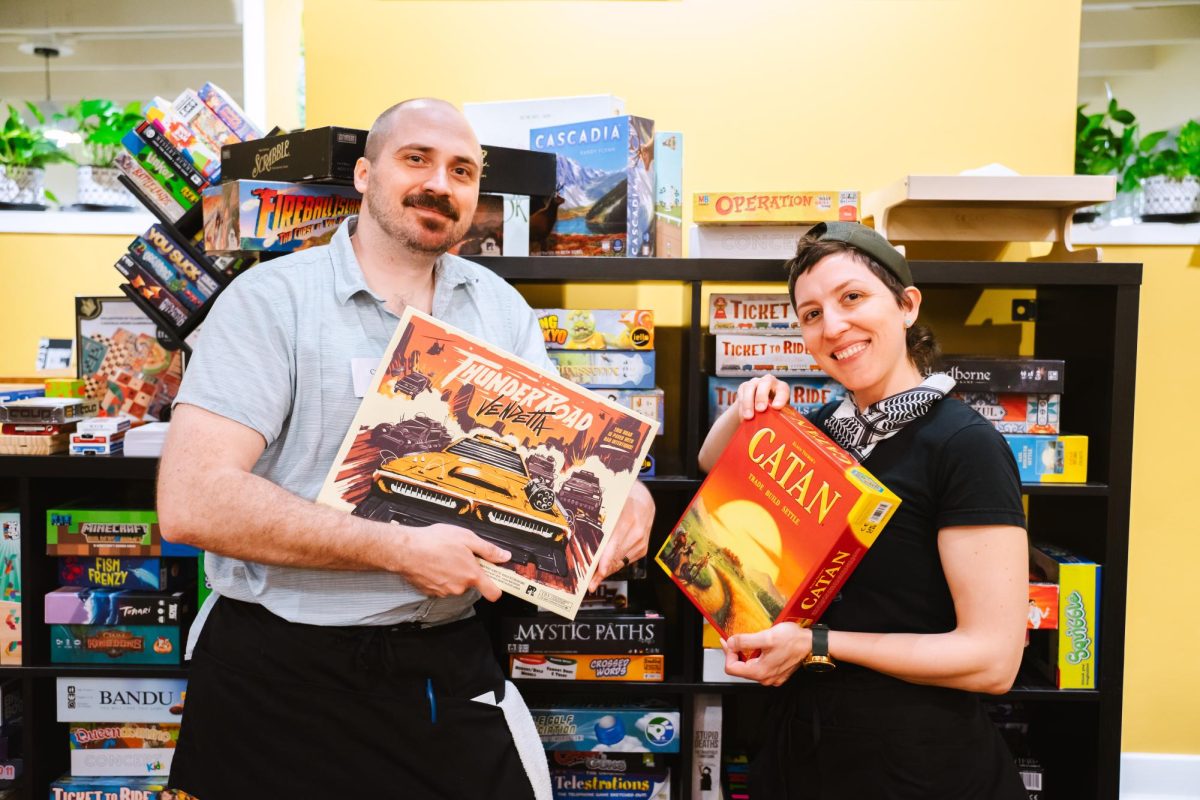 Coty Giannelli (Left) and Hayley Bennett (right) show off some of their favorite games at the Board and Bevy on April 28, 2024.