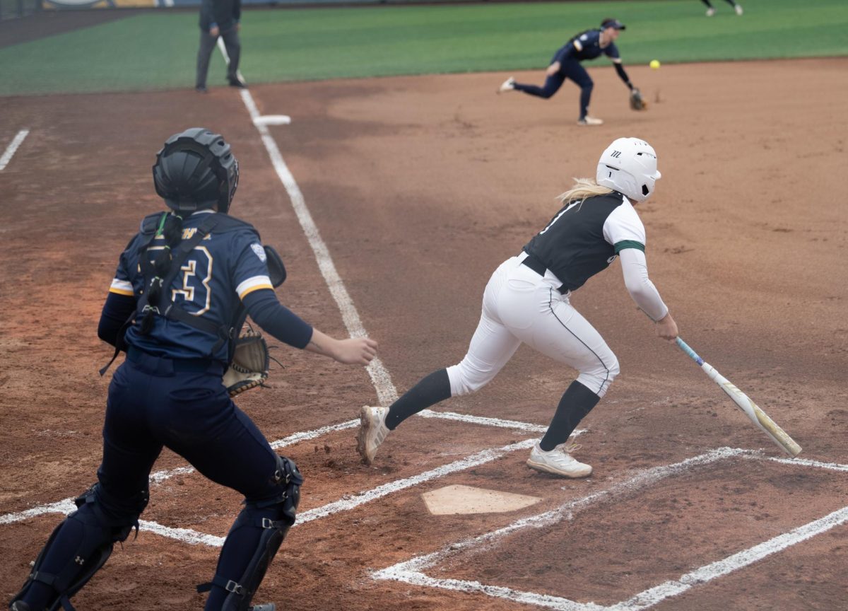 Ohios Lauren Yuhas pokes a ground ball past graduate student third baseman Alexandria Whitmore in the Golden Flashes 7-1 loss to the Bobcats in Game 1 on April 2, 2024.