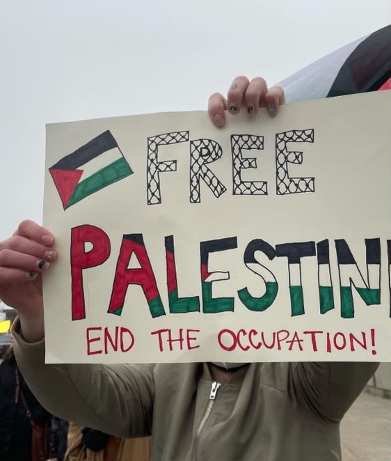 A student holding up a sign supporting Palestine.