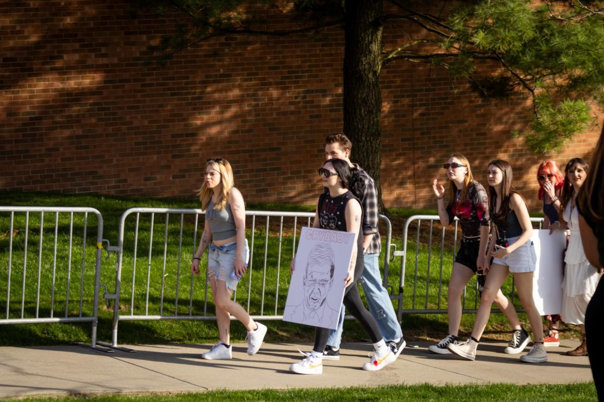 People walk with signs outside of the student center for the Rittenhouse event on April 16, 2024.
