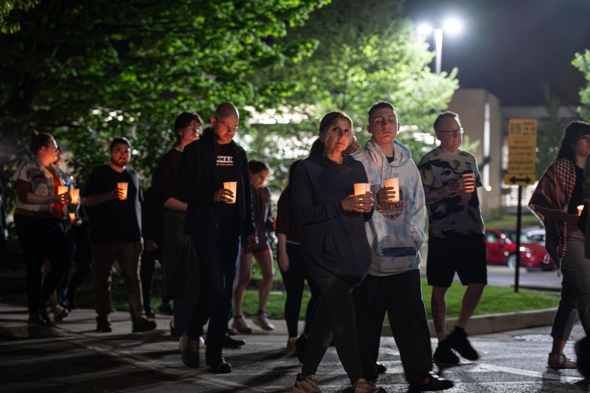 Participants of the Candlelight Walk and Vigil pass between the DI Hub and Oscar Ritchie Hall as they begin a circuit across campus May 3, 2024. 