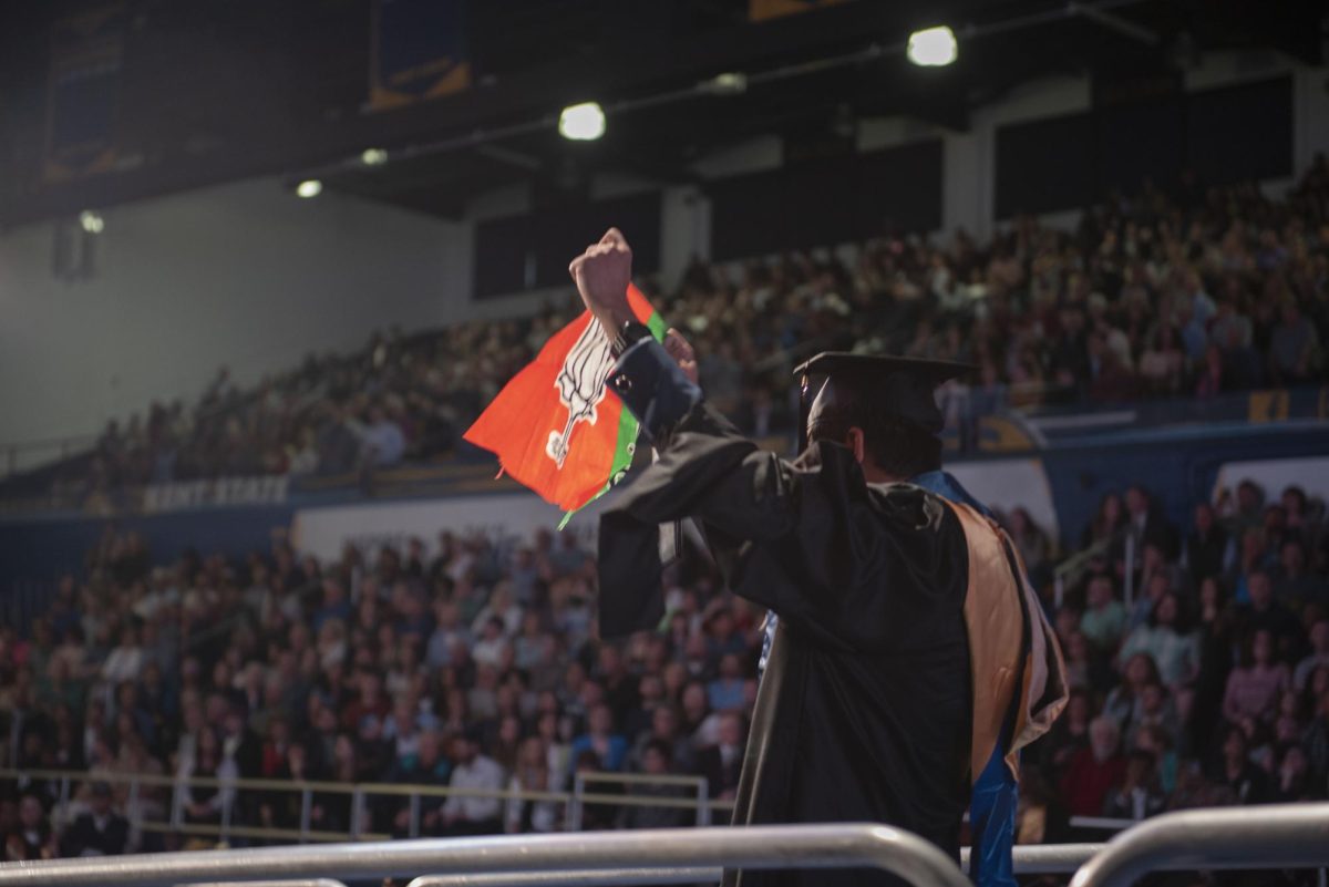 A student holds up a flag after receiving their diploma on May 9, 2024, at the masters, educational specialist and doctoral commencement in the Memorial Athletic and Convocation Center.