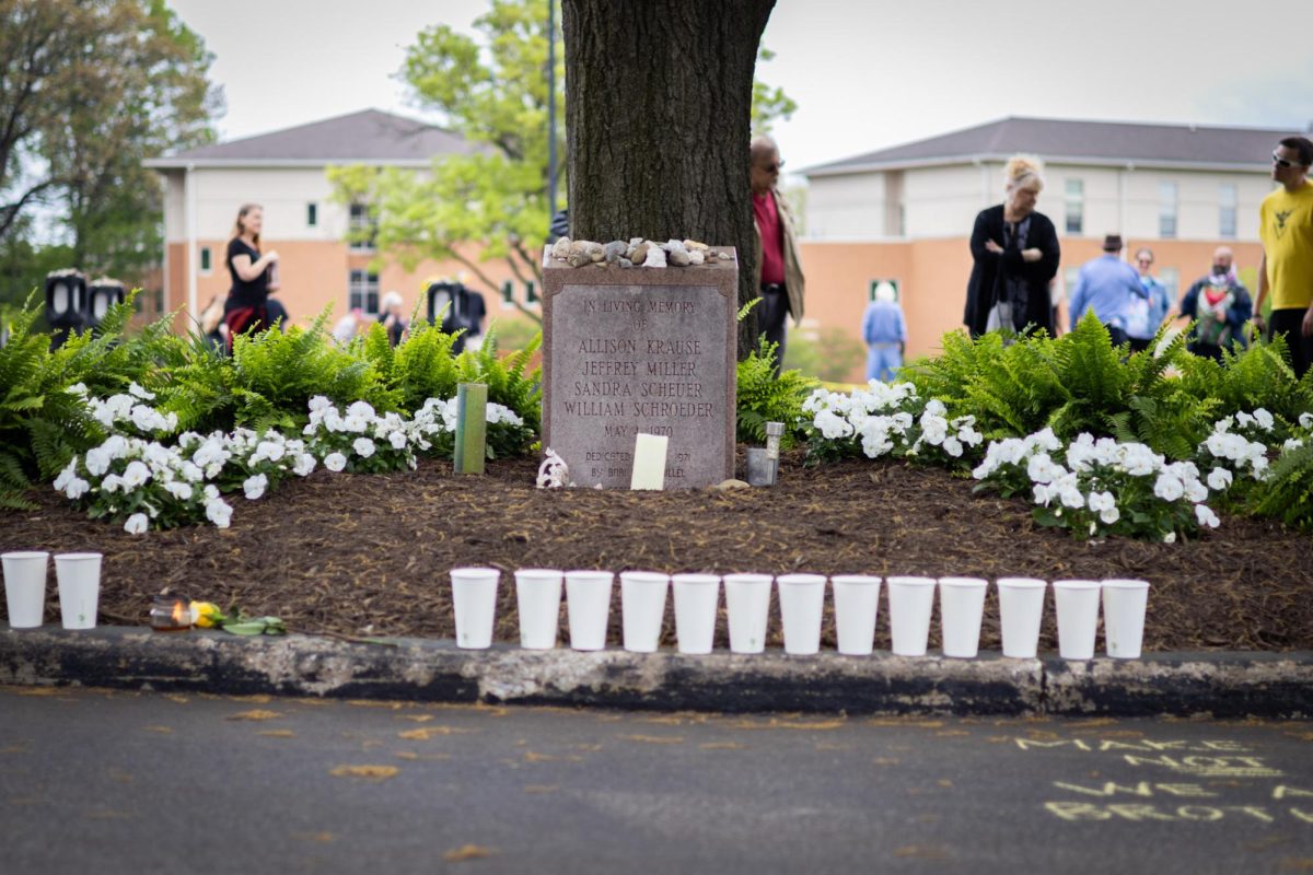 People walk around the Taylor Hall parking lot, where there are memorials to people killed during the May 4 protest on May 4, 2024.