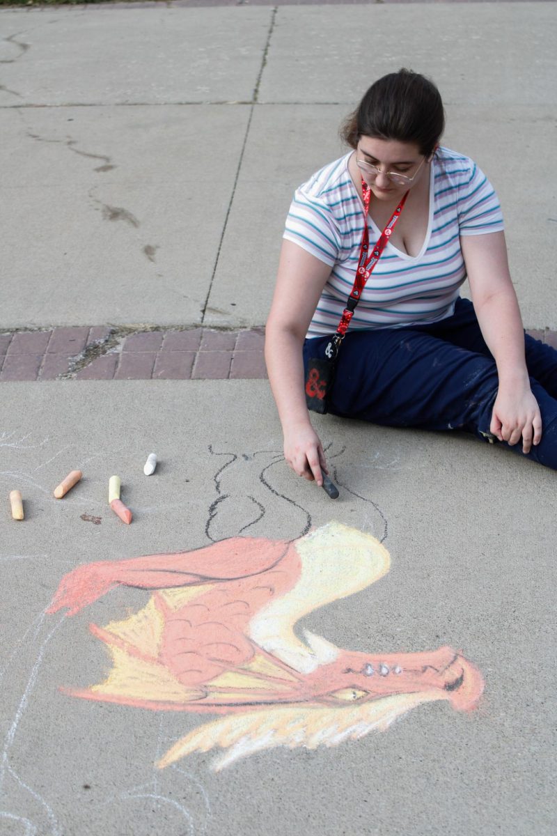 Sophomore Lia Swinehart draws a dragon during the Chalk Competition on Aug. 26, 2024.