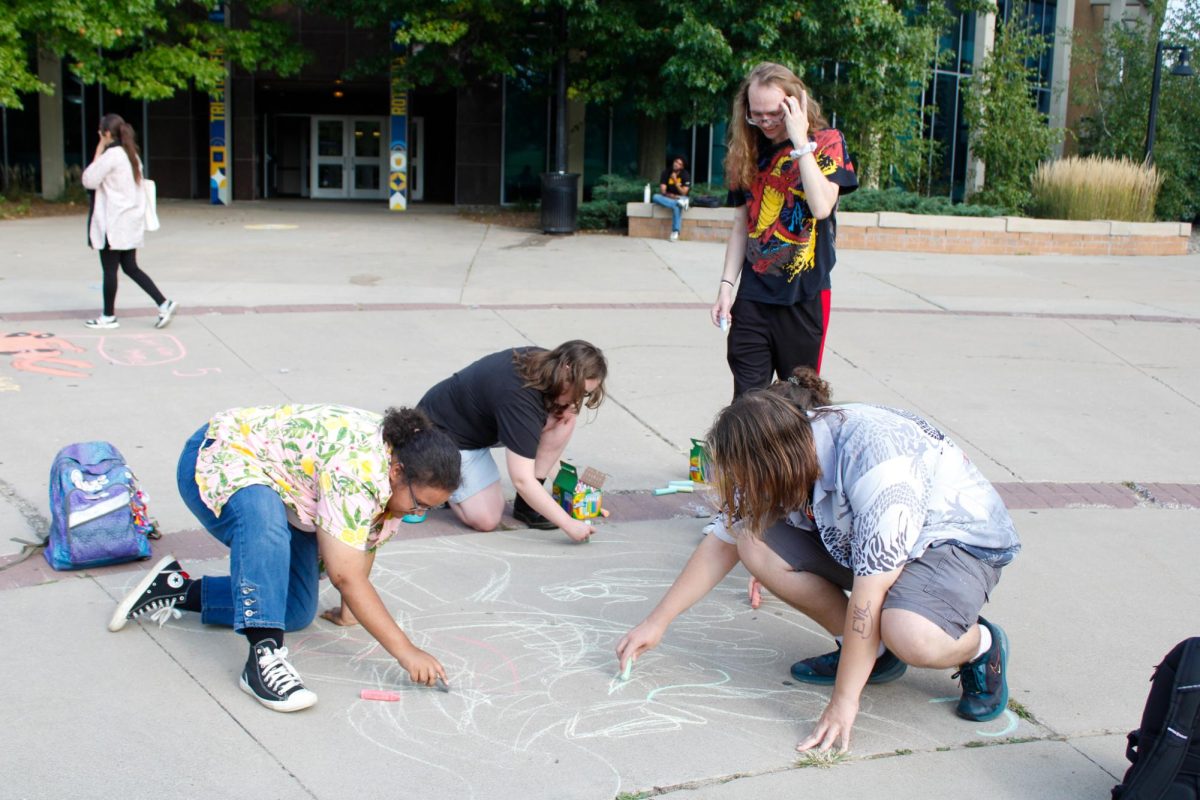 Chalk in hand, students take part in a chalk-art competition outside the Tri-Towers rotunda on Aug. 26, 2024.