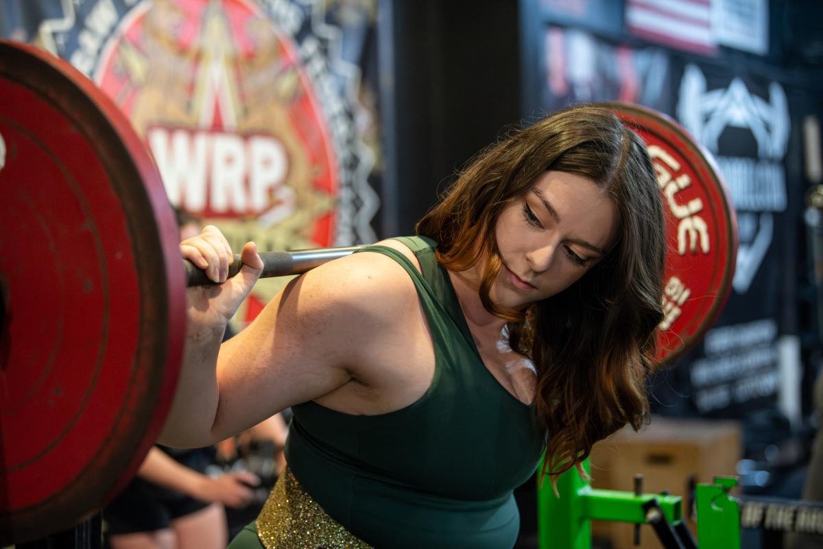 Kent senior musical theator major Ariel Brinker squats at Kent Barbell Club, Wednesday, Sept. 25, 2024.