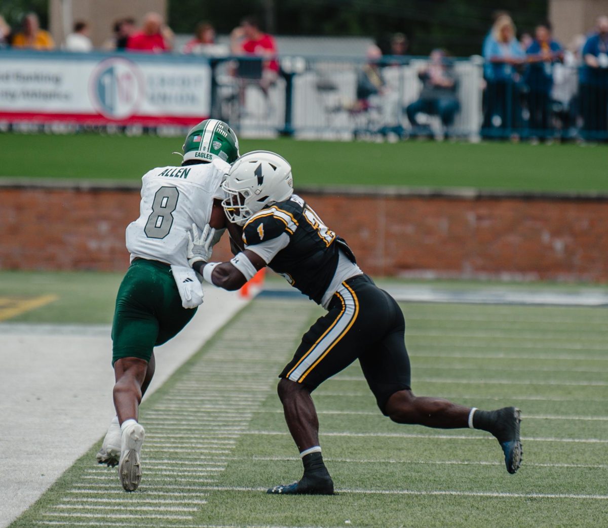 Junior safety Josh Baka pushes Markus Allen, an Eastern Michigan defensive back, out of bounds in the second quarter of the Homecoming game Sept. 28, 2024.