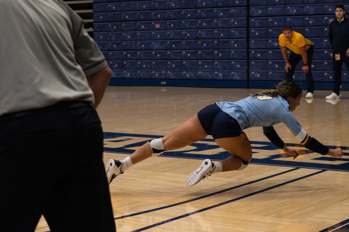 Redshirt Senior Karina Salinas dives for a ball at the volleyball game Friday night against Eastern Michigan. 