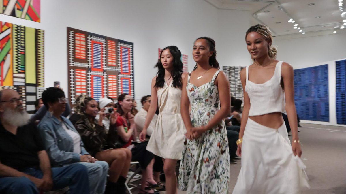 Noor Hamidullah walks down the runway with models wearing her designs at the Creator Collective's fashion show Sept. 27, 2024