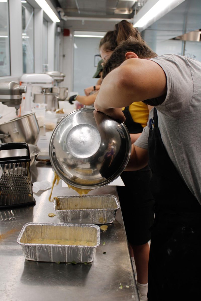 Sophomore, Nate Bergdorf pours dough for his recipe, Zucchini Bread, during a culinary class in the DI Hub on September 13, 2024. 