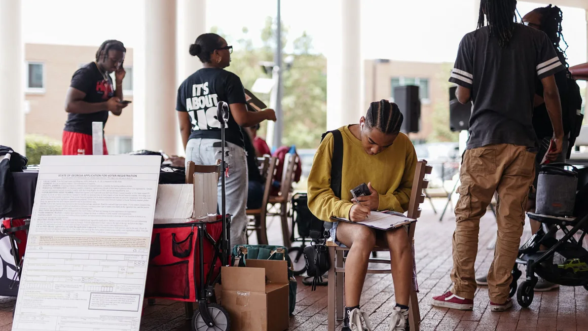 A Morehouse student fills out a voter registration form at a voter registration form at a voter registration booth at Morehouse College on August 19, 2024, in Atlanta, Georgia.