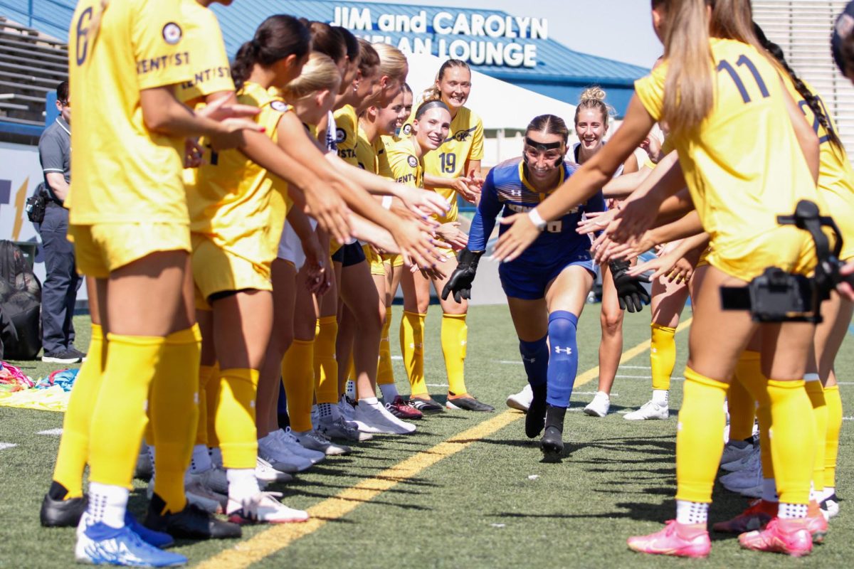 Kent Senior Goal-Keeper Heidi Marshall runs through the team during the introduction of the starting lineup before the match against Ball State University, Sept. 22, 2024.