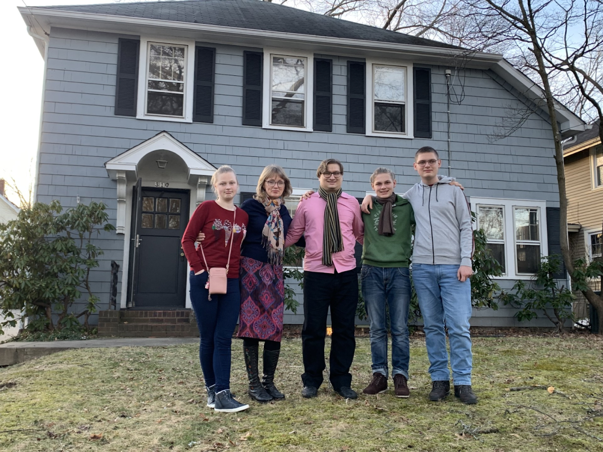 Kolya Koretskyy and his family stand outside their house in Kent, where they were relocated from Ukraine.