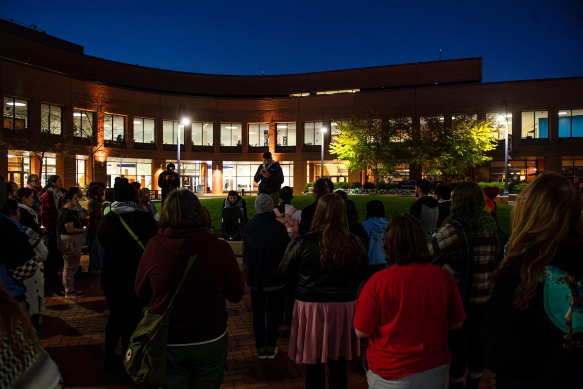 Attendees of Student's for Justice in Palestine's candlelight vigil gather at Riseman Plaza for the reading of names of those lost in the conflict, Thursday, Oct. 11, 2024.