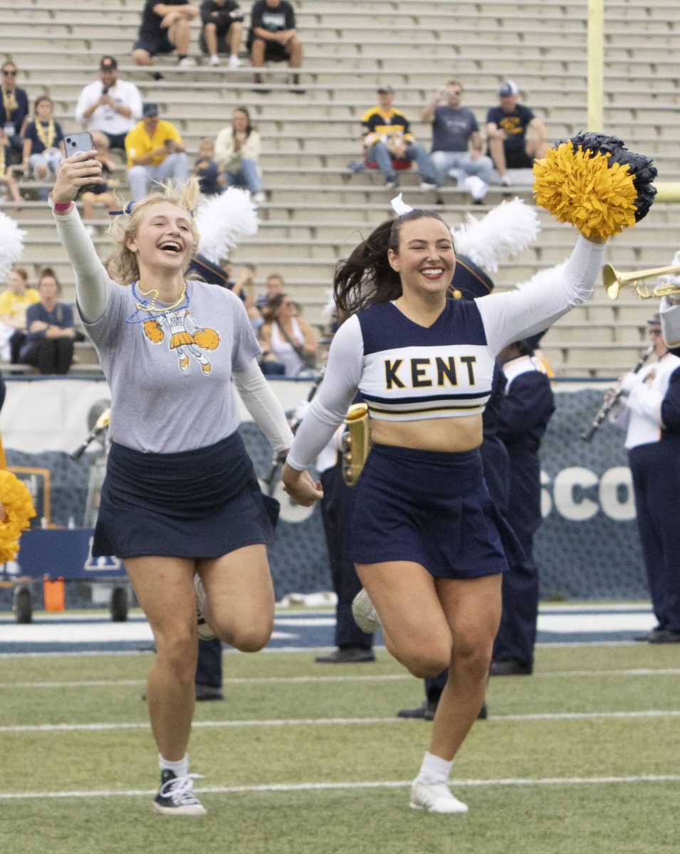 Two Kent State cheerleaders charge the field at the Homecoming football game against Eastern Michigan, Sept. 28, 2024.