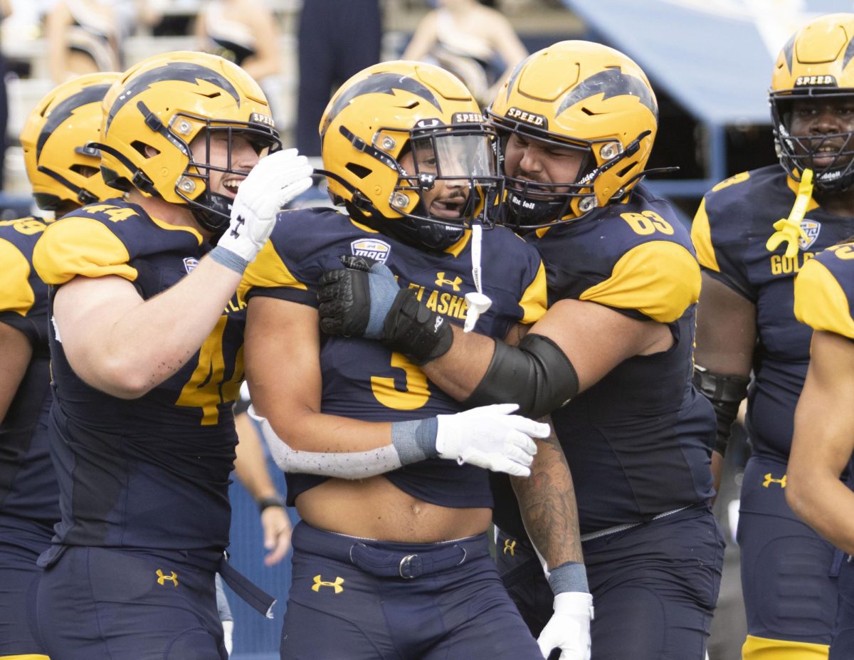 Freshman linebacker Rocco Nicholl (44) and freshman offensive lineman Josh Prusinowski (63) congratulate senior safety Dean Clark (3) on his touchdown at the Oct. 12, 2024 football game against Ball State University.