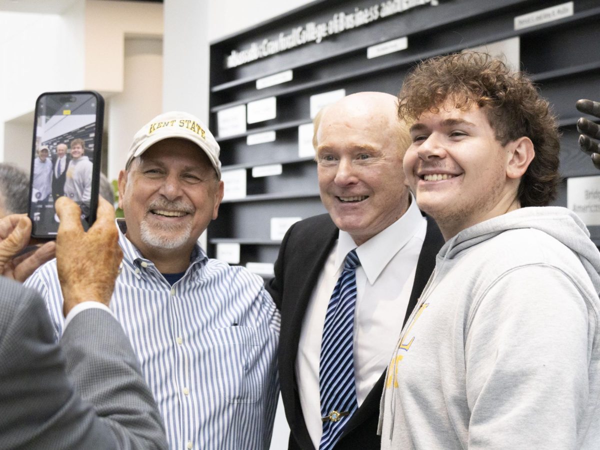 Ambassador Edward F. Crawford takes a photo with two attendees at the Sept. 27, 2024 grand opening of Crawford Hall.