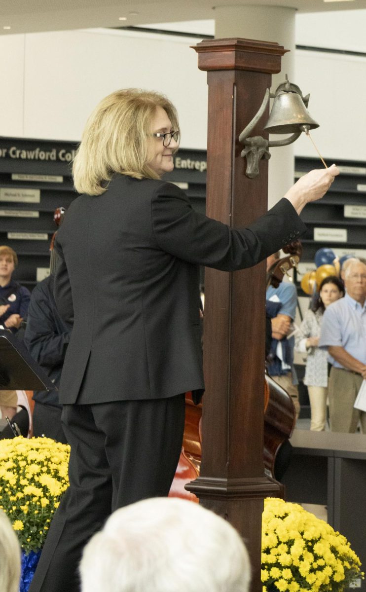 At the Sept. 27, 2024 grand opening, Deborah Spake, Dean of the Ambassador Crawford College of Business and Entrepreneurship rings the bell signifying the opening of Crawford Hall.