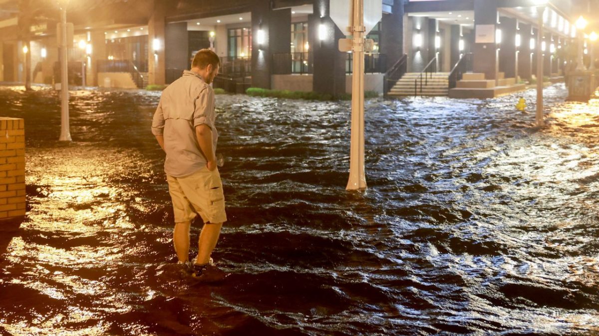 Brandon Marlow walks through surge waters flooding the street after Hurricane Milton came ashore in the Sarasota area in Fort Myers, Florida, on October 09, 2024.