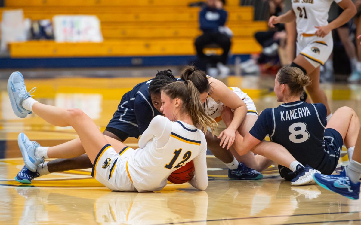 Kent senior Jenna Batsch, 12, fights to retain control of the ball during the third quarter of the game against Xavier, Saturday, Nov. 23, 2024.