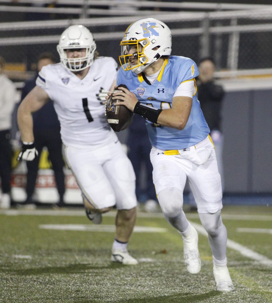 Kent State University junior quarterback Tommy Ulatowski runs with the ball during a play against Akron University in their rival match on November 19,2024.