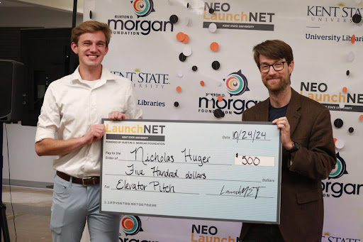 Huger holds his third-place prize in the 2024 Elevator Pitch for Boobys Coffee and Tea. 